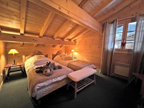 1 Schlafzimmer mit 2 Betten in einem Blockhaus in der Unterkunft PATURAGE Demi chalet 4 chambres in La Clusaz