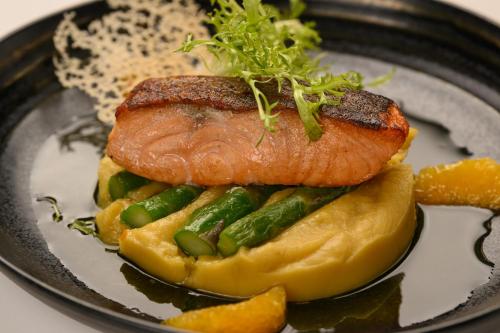a plate of food with a piece of salmon and vegetables at Inspira Liberdade Boutique Hotel in Lisbon