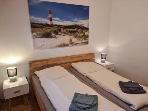 a bedroom with two beds and a lighthouse on the wall at Haus Reihernest in Sehestedt