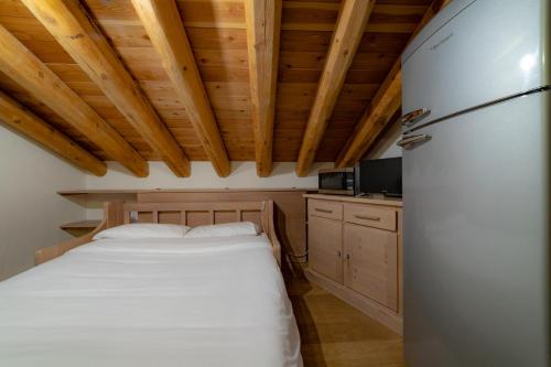 a bedroom with a white bed and wooden ceilings at Walsertal Residence in Gressoney-la-Trinité