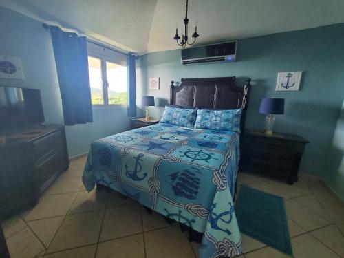 a bedroom with a bed with blue walls at FunSea Water View Apt in Culebra