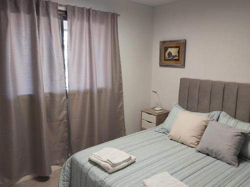 um quarto com uma cama com duas toalhas em Luminoso departamento en zona residencial em Mendoza