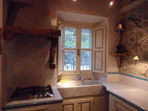 a kitchen with a sink and a stove and a window at Agriturismo Pratofranco in Pontremoli