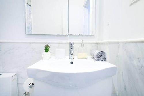 a white bathroom with a sink and a mirror at 62-3B Studio Prime UES Walk to Central Park in New York