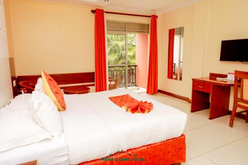MeruMeru Slopes Hotel的一间卧室，配有一张床、一张书桌和一扇窗户