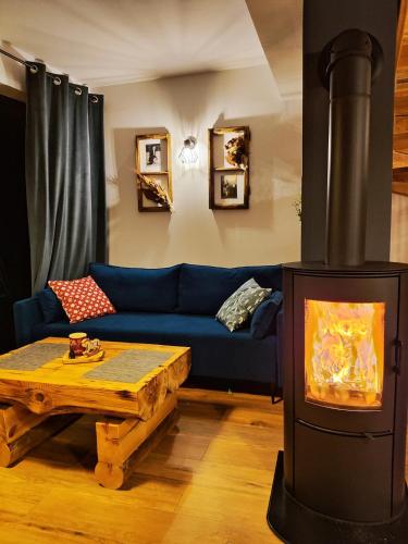a living room with a blue couch and a wood stove at Przystanek Gorce in Nowy Targ