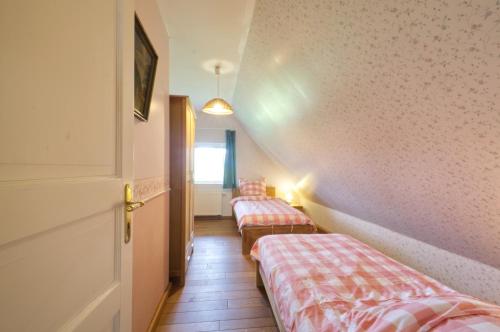 two beds sitting in a room with a hallway at Reetdachhaus mit großem Garten und Kamin in Marlow
