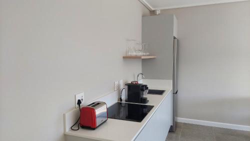 a kitchen with a red appliance on a counter at Hilltop Bayview Luxury Apartments in Plettenberg Bay
