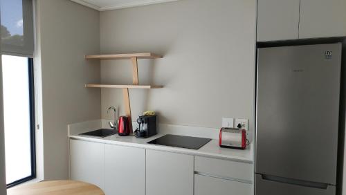 a kitchen with white cabinets and a counter top at Hilltop Bayview Luxury Apartments in Plettenberg Bay