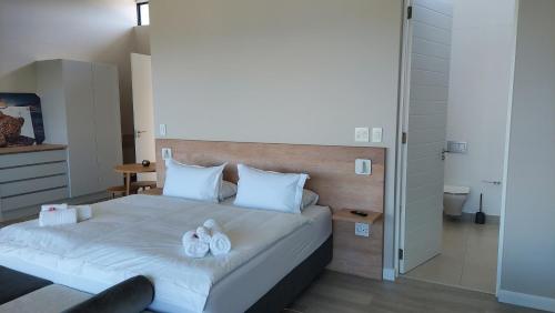 a bedroom with a bed with white towels on it at Hilltop Bayview Luxury Apartments in Plettenberg Bay