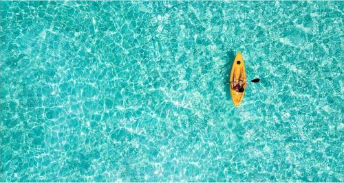 a yellow kayak in the middle of the water at New Listing La Vista Azul Spacious 1 Bedroom Condo in Turtle Cove