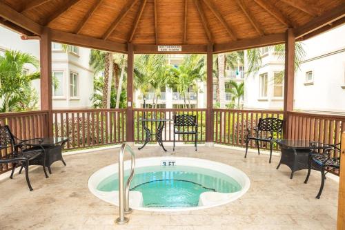 a hot tub on a patio with tables and chairs at New Listing La Vista Azul Spacious 1 Bedroom Condo in Turtle Cove