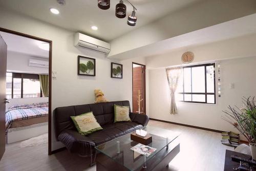 a living room with a couch and a glass table at 新宿市中心JR线新大久保三分钟紧邻韩国街免费Wi-Fi in Tokyo