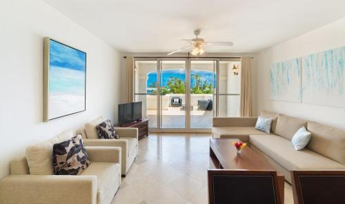 a living room with two couches and a tv at New Listing La Vista Azul Spacious 1 Bedroom Condo in Turtle Cove