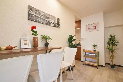 a dining room with white chairs and a table at 新宿市中心JR线新大久保三分钟紧邻韩国街免费Wi-Fi in Tokyo