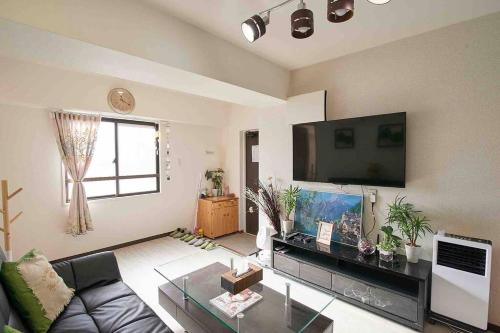 a living room with a couch and a flat screen tv at 新宿市中心JR线新大久保三分钟紧邻韩国街免费Wi-Fi in Tokyo