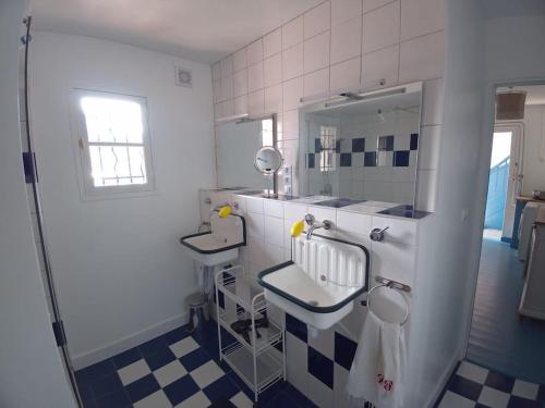 ein Bad mit einem Waschbecken und einem Spiegel in der Unterkunft Rochefort, Charentaise 3 à 7 personnes, 3 étoiles in Rochefort