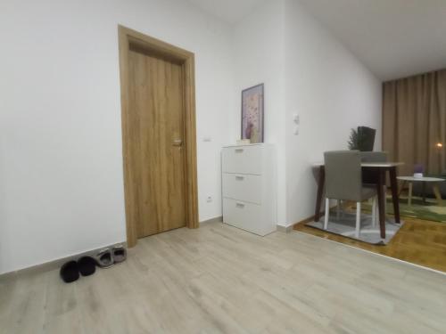 an empty living room with a door and a table at Apartman Ledine in Ledine