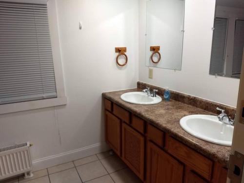 een badkamer met 2 wastafels en een spiegel bij North Getaway Cottage in Williamstown