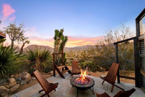 a patio with a table and chairs and a fire pit at Hi View House in Joshua Tree