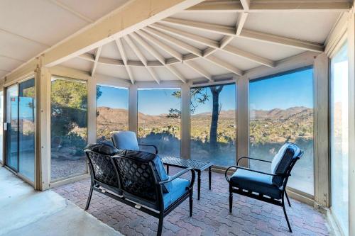 a screened in porch with chairs and a table at Hi View House in Joshua Tree