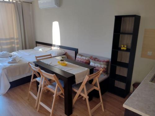 a room with a bed and a table and chairs at Студио Пацо и Нина в AspenValley in Razlog