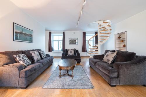 a living room with two couches and a table at Old Town - Vana Viru Apartment in Tallinn
