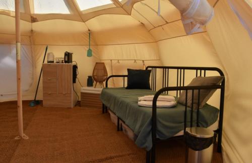 a bedroom with a bed in a tent at Stargazer Tent met sterrenuitzicht in Callantsoog