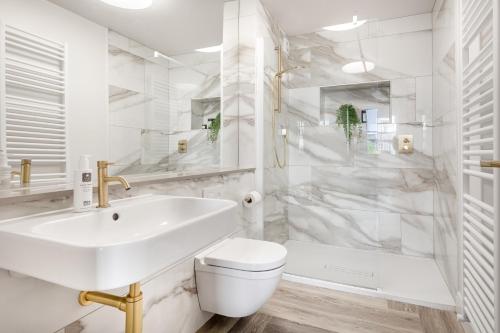 a white bathroom with a sink and a toilet and a tub at Esperance - Brand New, luxury studio with parking in Bowness-on-Windermere