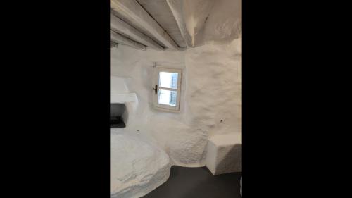 Habitación pequeña con paredes blancas y ventana. en Room in Studio - Artemis Studio Pyrgi en Platis Gialos