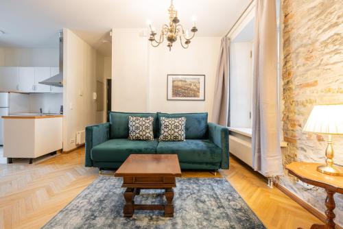 un soggiorno con divano verde e tavolo di Old Town - Viru Gate Apartment a Tallinn