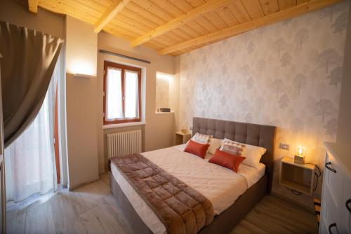 una camera da letto con un grande letto con due cuscini rossi di BuonVivere House a Verduno