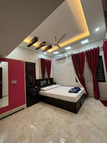 a bedroom with a bed and red drapes at Heaven Stay in Varkala