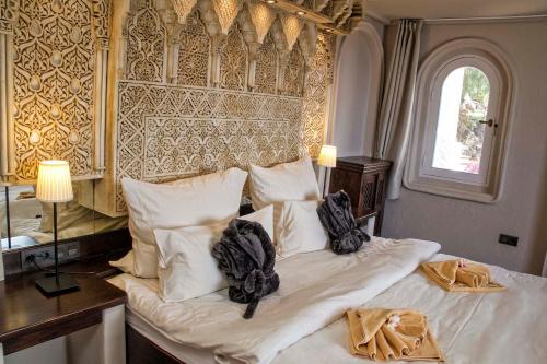 Schlafzimmer mit einem Bett mit weißer Bettwäsche und einem Fenster in der Unterkunft El Refugio Apartments & Villa in La Matanza de Acentejo