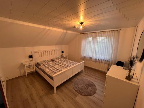 een slaapkamer met een bed, 2 tafels en een raam bij Ferienhaus Lotte in Detern