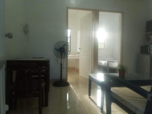 uma sala de estar com uma mesa e uma ventoinha em Kendall Place Apartment em Cagayan de Oro