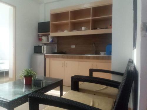 uma cozinha com uma mesa e duas cadeiras e um balcão em Kendall Place Apartment em Cagayan de Oro