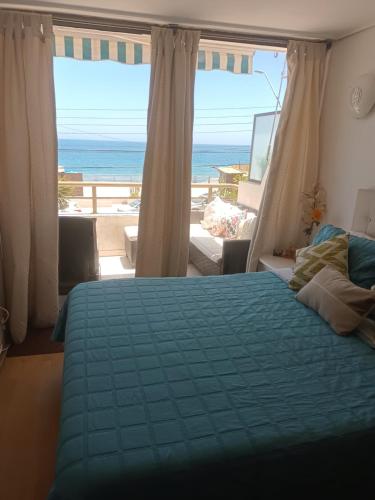 1 dormitorio con cama y vistas al océano en Departamento Frente al Mar, en Concón