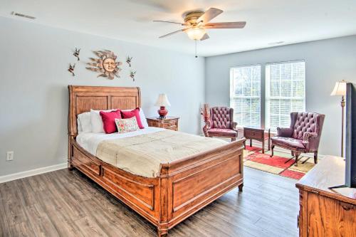 a bedroom with a bed and two chairs and a ceiling fan at Chic Gastonia Home with Deck, Fire Pit and Grill! in Gastonia