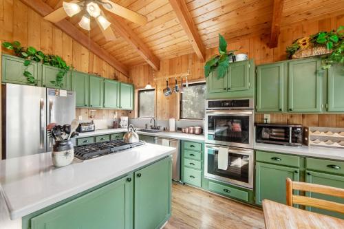 a kitchen with green cabinets and a wooden ceiling at Tahquitz Rock Lodge in Idyllwild