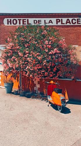 an orange scooter parked in front of a hotel place at Hotel de la Place in Loyettes
