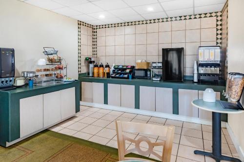 a kitchen with a counter and a table and a chair at Days Inn by Wyndham Del Rio in Del Rio