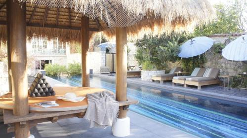 un resort con piscina, tavolo e ombrellone di Alavya ad Alaçatı