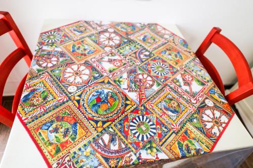 a chair with a colorful cushion on top of it at Cà del Re Holiday in Partinico