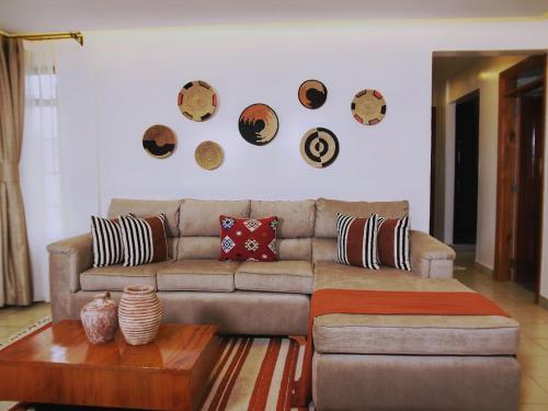 a living room with a couch and plates on the wall at Zendo Suite in Nairobi