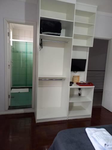 a room with white shelves in a room with a bed at Pousada Minha Casa- Aconchegante no Centro de São Lourenço in São Lourenço