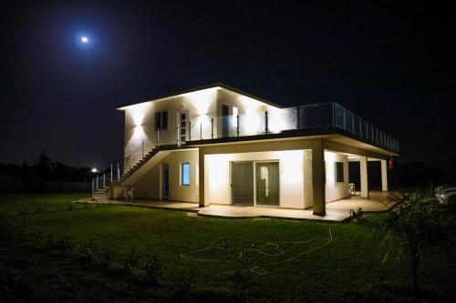Cà del Re Holiday في بارتينيكو: بيت ابيض كبير بالليل مع القمر