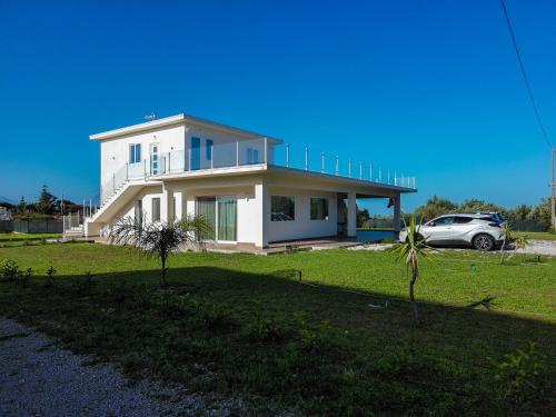 a white house with a car parked in front of it at Cà del Re Holiday in Partinico