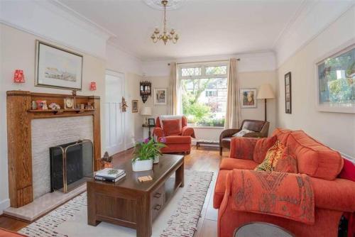 a living room with red furniture and a fireplace at Delightful Family Home in Lisburn