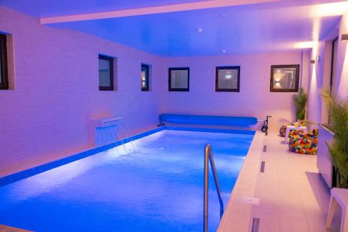 a swimming pool in a house with blue lighting at Hotel Aura Unirii in Alba Iulia